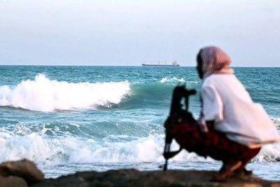 A Somali pirate keeps watch on the coastline near Hobyo, northeastern Somalia. AFP