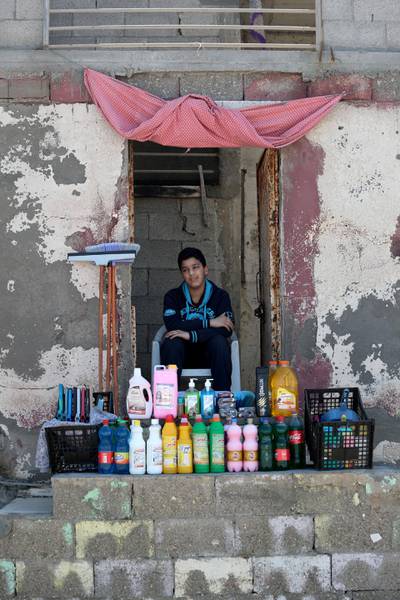 A Palestinian boy sells cleaning tools and sanitisers amid concerns over the spread of coronavirus, at Beach Refugee Camp in Gaza City, Palestine, on March 22, 2020. Reuters