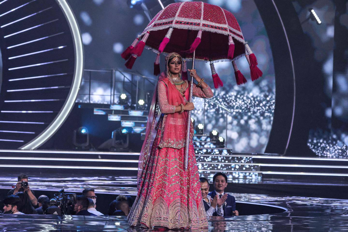 Miss India Harnaaz Sandhu wore a gold embellished pink lehenga and carried a traditional wedding parasol. AFP