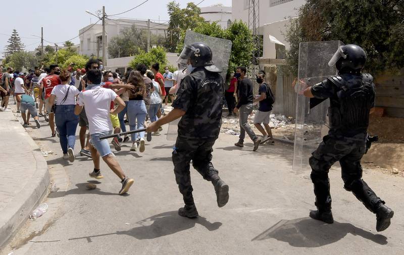 Members of Tunisian security forces charge to disperse anti-government demonstrators during a rally in front of the Parliament in the capital Tunis.
