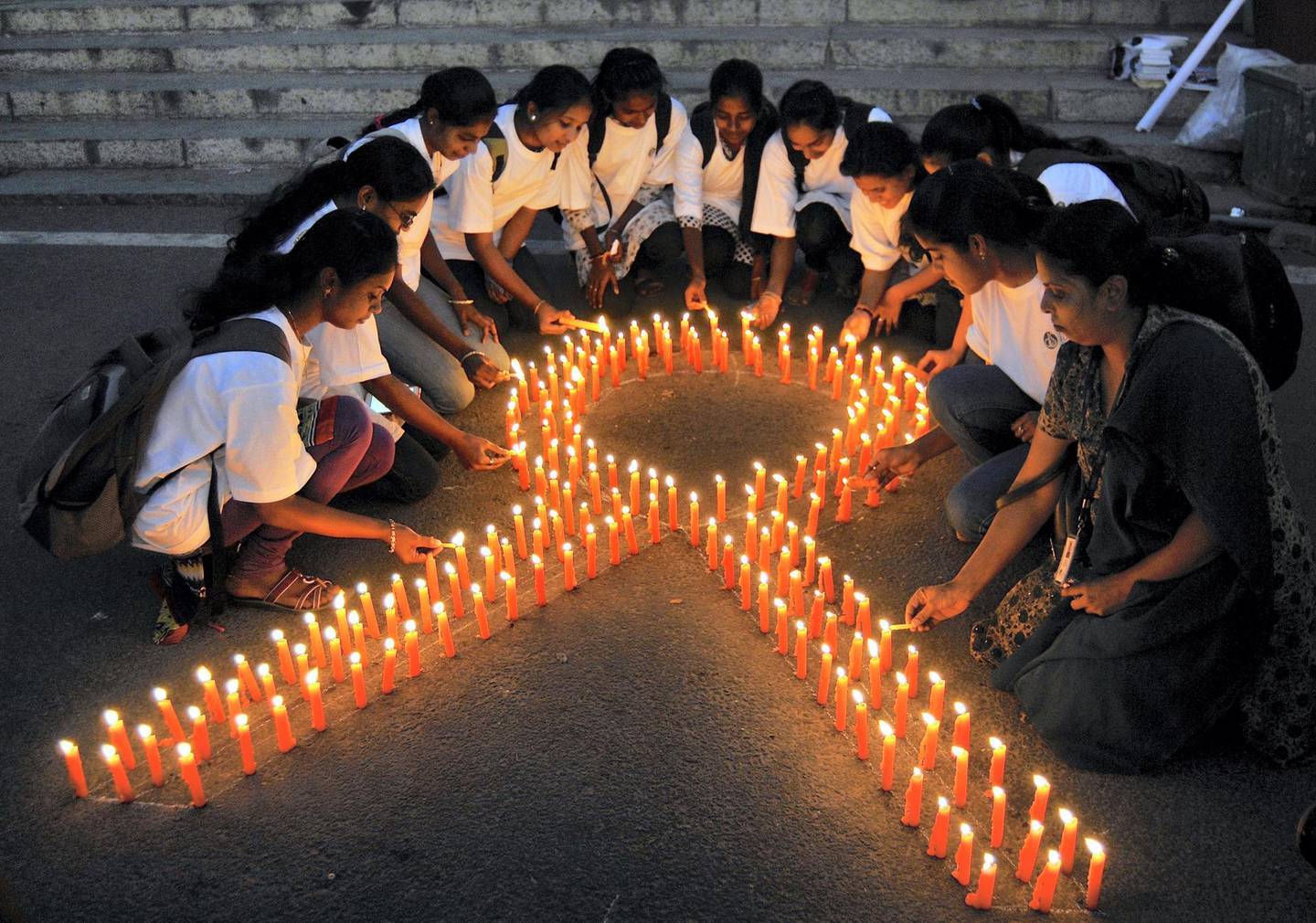Staff members of a government-run pharmaceutical college light candles arranged in the formation of a ribbon to promote cancer awareness and mark World Cancer Day, in the southern Indian city of Bengaluru, formerly known as Bangalore, February 4, 2015. REUTERS/Abhishek N. Chinnappa (INDIA - Tags: HEALTH SOCIETY ANNIVERSARY)