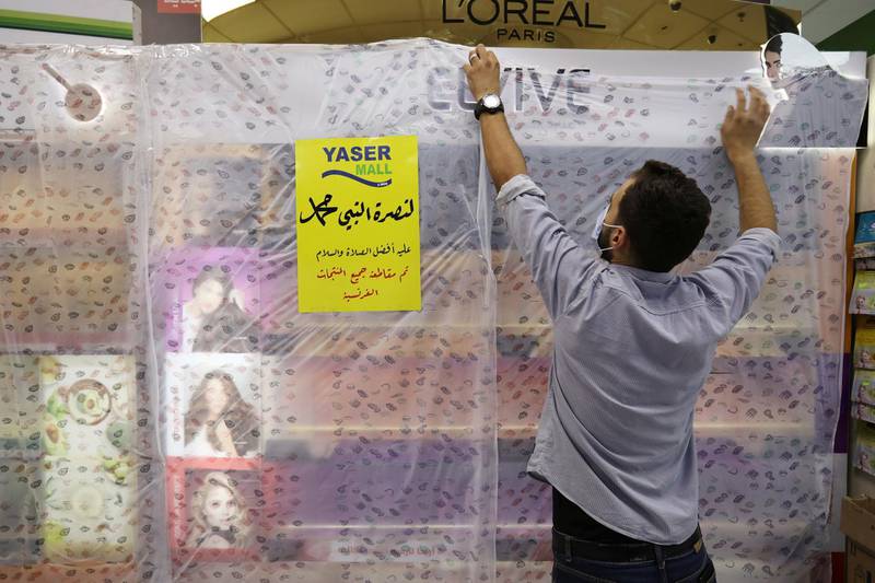 A worker of a mall covers French products in protest against French cartoons of the Prophet Mohammed in Amman, Jordan. The cover reads in Arabic 'In solidarity with the Prophet Mohammed peace be upon him, all French products have been boycotted'. Reuters