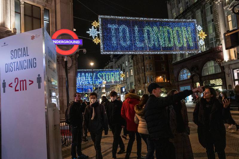 Members of the public walk under Christmas lights on Oxford Street. Getty Images