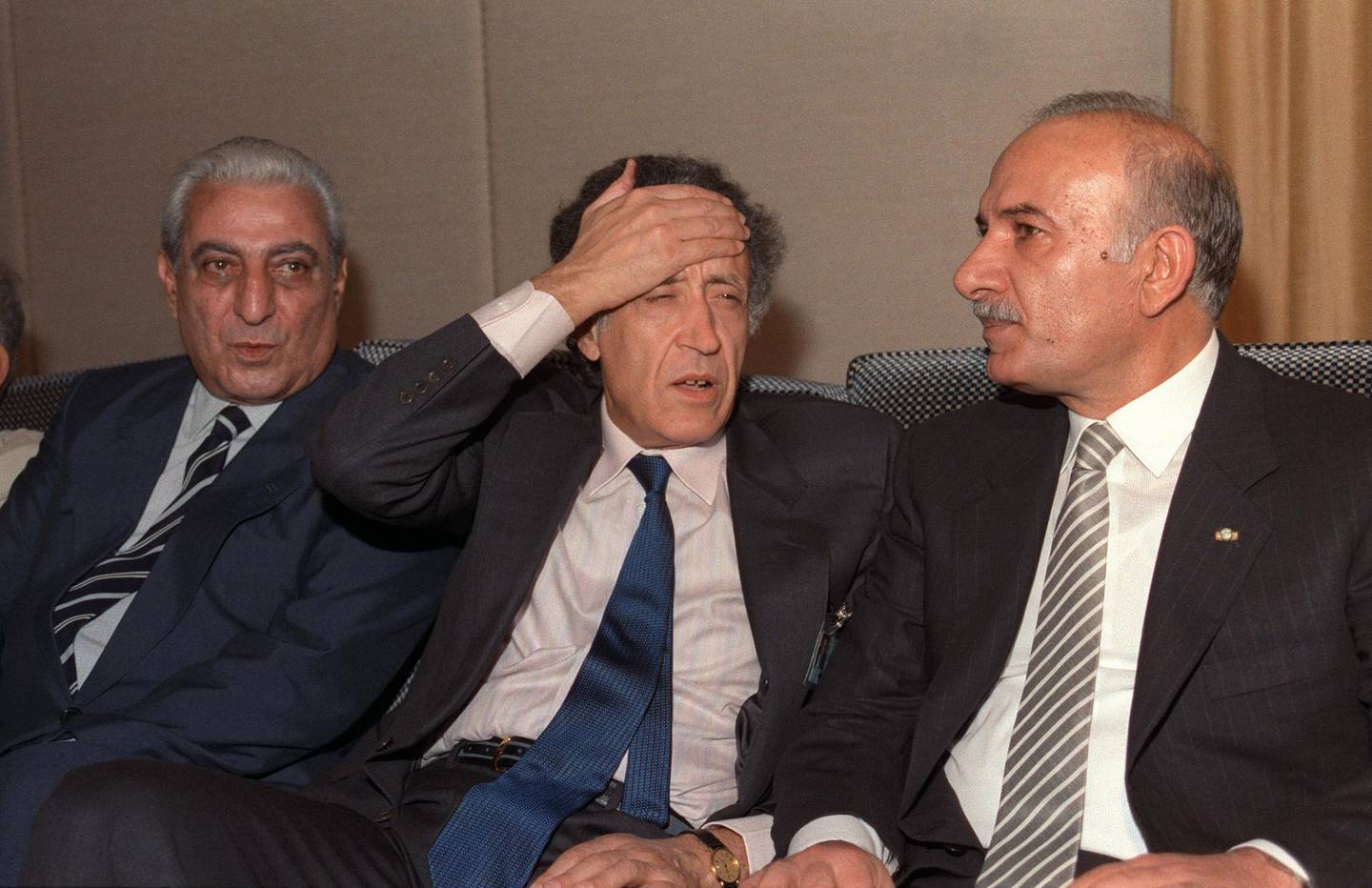 Sitting between Lebanese Parliament speaker Hussain al-Hussaini (R) and deputy Abdelallah Rassi (L), the Arab League envoy, Algerian Lakhdar Ibrahimi puts his hand on his forehead 29 September 1989 in Taif after the members of Lebanese National Assembly started to discuss the charter of national reconciliation. The session was attended by 31 Christian and 31 Muslim MP's. At a further meeting 22 October 1989, the charter of national reconciliation (the Taif Agreement) was endorsed by 58 of the 62 deputies attending the session. The Taif agreement provided for the transfer of executive power from the presidency to a cabinet, with portfolios divided equally among Christian and Muslim ministers. (Photo by NABIL ISMAIL / AFP)
