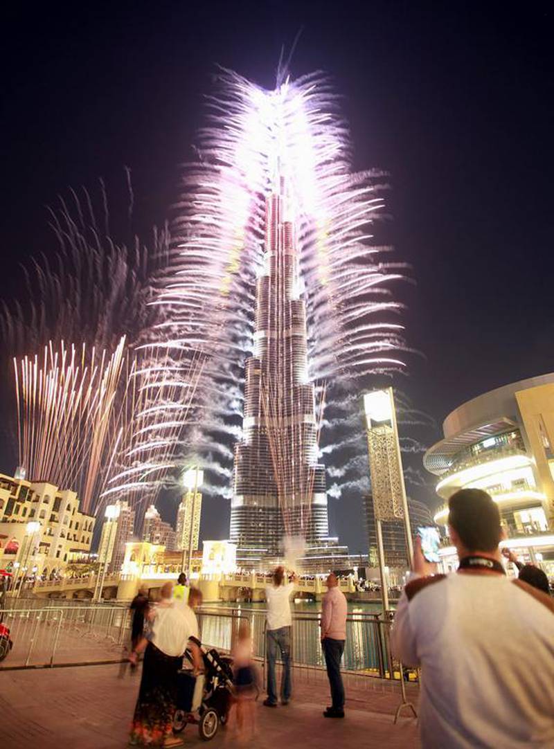 epa03967522 People watch fireworks during celebrations after Dubai won to host the World Expo 2020 in front of world's tallest building, the Burj Khalifa, in Dubai, United Arab Emirates, 27 November 2013. Dubai had won the last round of voting with 116 votes, against the Russian city of Ekaterinburg. Dubai became the first Middle East city to host the global event following the voting at the Bureau International des Expositions (BIE), which is the governing body of world's fairs.  EPA/ALI HAIDER