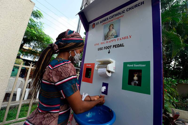 A woman washes her hands outside church. Bans on religious gatherings lifted across Nigeria in early August. Pius Utomi Ekpei / AFP