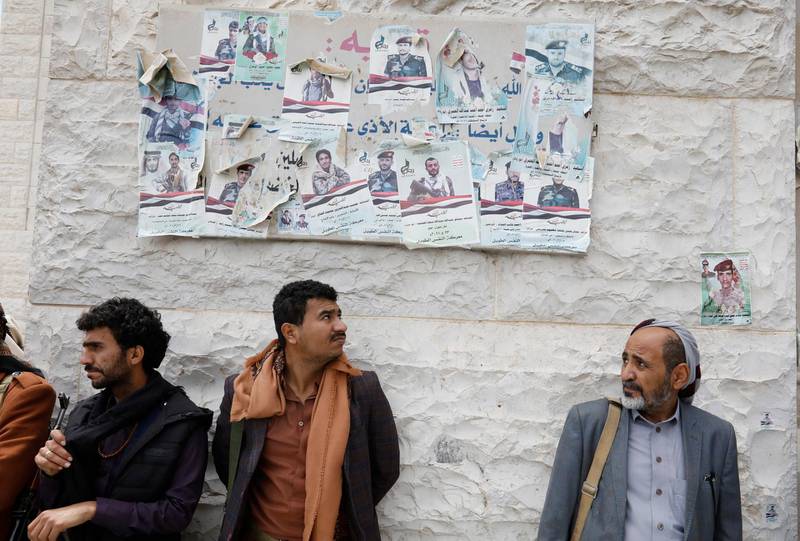 Armed Houthi supporters stand beneath posters depicting Houthi fighters who were allegedly killed in the Marib offensive, during their funeral outside a mosque in Sana'a. EPA