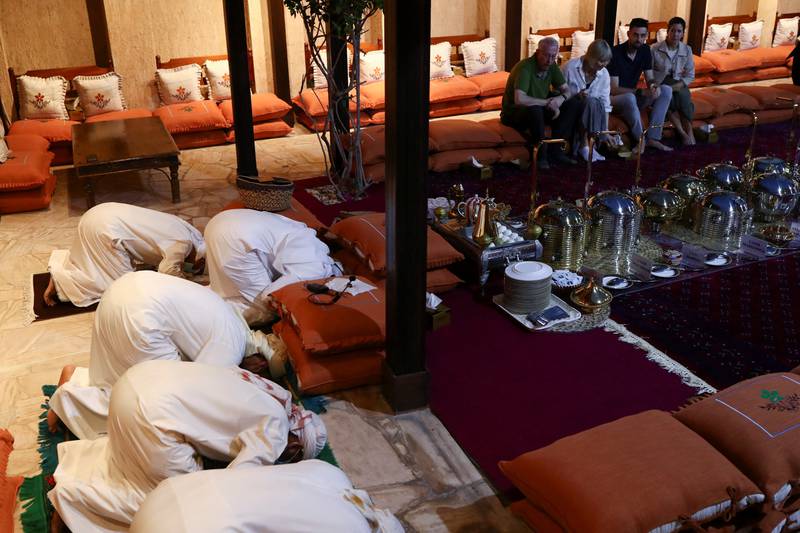 Muslims pray as visitors watch and learn during an iftar event to introduce tourists and visitors to the culture of Emirati iftar at Ramadan held in the Sheikh Mohammed Centre for Cultural Understanding in Dubai.