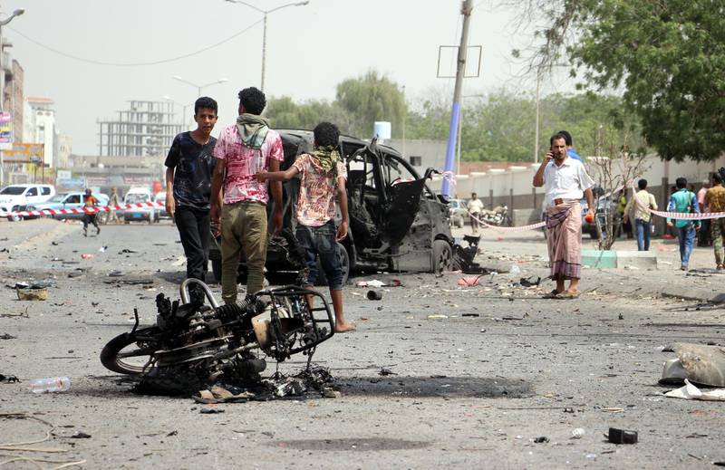 Aden residents inspect the site of a car bomb attack that targeted a police station.  EPA