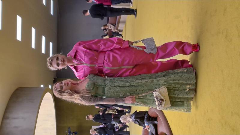 Inside the Gucci show, a mix of styles with one visitor wearing a printed, maxi dress and another in a pink satin jumpsuit