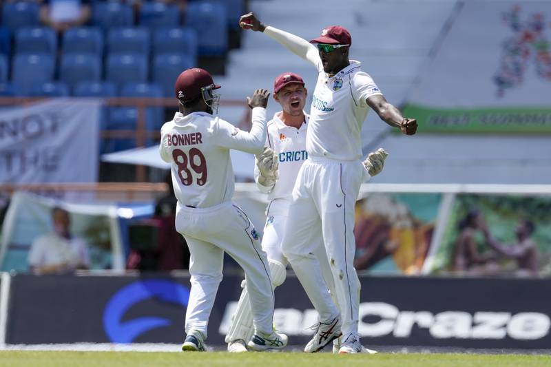 West Indies fielder Jason Holder, right, celebrates after taking the catch to dismiss England's Chris Woakes. AP