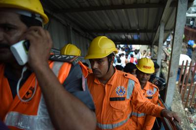 Indian rescue personnel walk through the scene of a stampede on a railway bridge in Mumbai. AFP