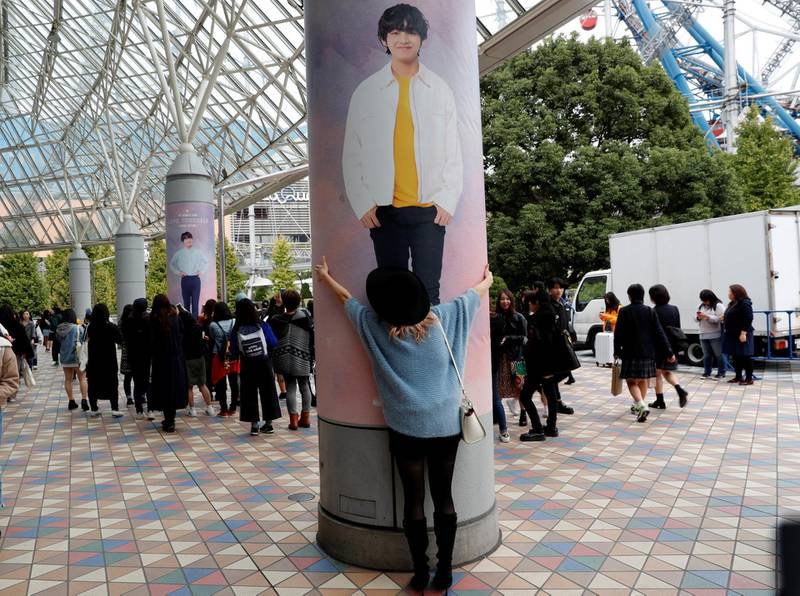 A woman hugs a wall photo of a member of South Korean boy band BTS outside Tokyo Dome. Kim Kyung-Hoon / Reuters