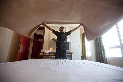 Ajman, August 8, 2011 - Subash Babu, from India, changes the bedding in one of the rooms of the Landmark Suites Hotel in Ajman City, Ajman, August 8, 2011. Babu, who has a brother living in Dubai,  immigrated to the UAE nine years ago and has worked in foodstuffs sales in Ras al Khaimah, stationary sales in Abu Dhabi and now at the Landmark. "It (Ajman) is a little, silent place with not too much hurry and life is good," Babu says of Ajman City. He does miss his wife and two children who are still in India who he says he call everyday. (Jeff Topping/The National) 