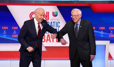 Democratic US presidential candidates Joe Biden and Senator Bernie Sanders greet each other with an elbow bump in place of a handshake before the start of the 11th Democratic candidates’ debate. Reuters