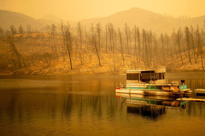 A boat scorched by the Carr Fire floats on Whiskeytown Lake in Whiskeytown, California. AP Photo / Noah Berger