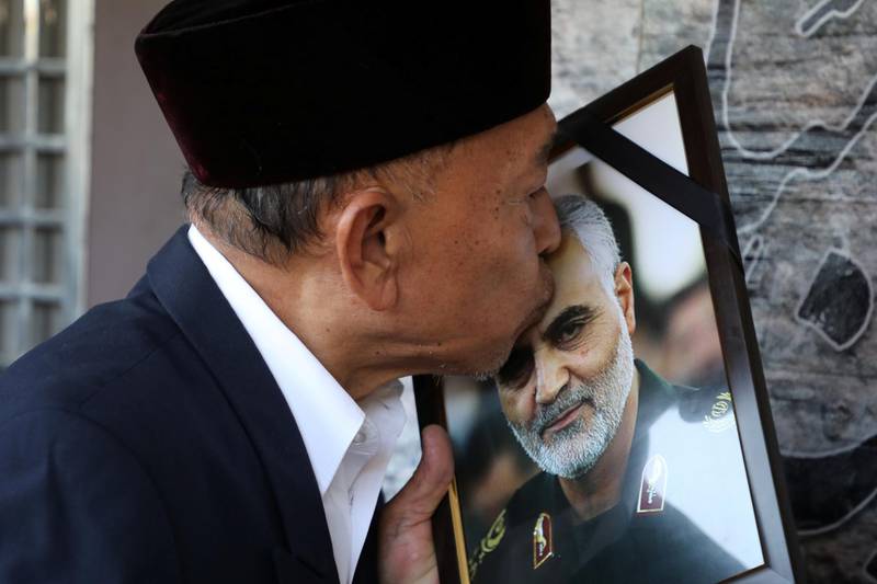 A man kisses a picture of Qassem Suleimani outside the Embassy of Iran in Kuala Lumpur, Malaysia. Reuters