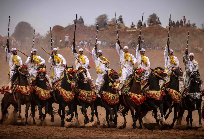 Moroccan horsemen raise their rifles during a traditional horse riding performance at a Moussem culture and heritage festival in the capital Rabat, on August 27, 2022.  (Photo by FADEL SENNA  /  AFP)
