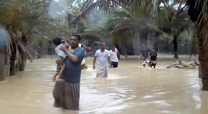 An image grab taken from an AFPTV video shows people walking through flood water as they evacuate a flooded area during a cyclone in the Yemeni island of Socotra. Seven people were missing and hundreds others evacuated from their homes after a cyclone hit the Yemeni island the previous night, causing severe flooding and damage to houses, officials said.
 / AFP / AFPTV / STRINGER

