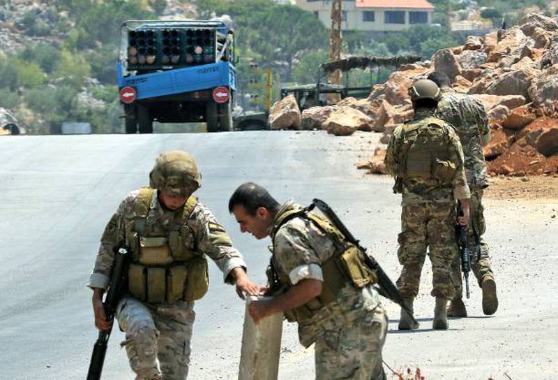 Lebanese soldiers stand near a lorry carrying a rocket launcher after residents confiscated it in the southern village of Chouya on August 6.