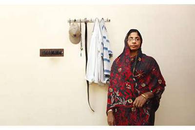 May 28, 2010 - India - Rasiya Eramacka Veedu, 48 stands beside a few of her husband's belongings at the family's home in Calicut. Rasiya's husband, Moideen Koya, has recently returned to Calicut after working in Abu Dhabi for 32 years. Charla Jones for The National