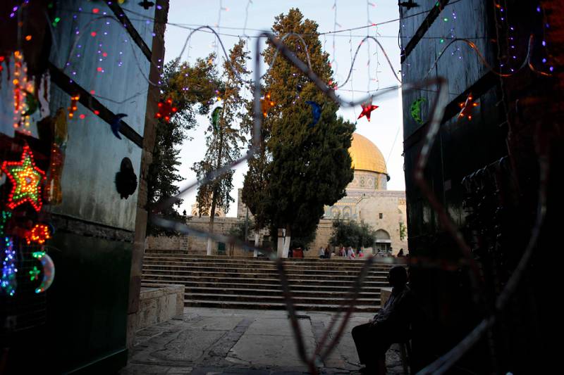A Palestinian man sits next to decorations at the entrance to the compound of The Dome of the Rock in Jerusalem's Old City July 8, 2013, ahead of the upcoming holy month of Ramadan. REUTERS/Ammar Awad   (JERUSALEM - Tags: RELIGION) *** Local Caption ***  NIR03_ISRAEL-_0708_11.JPG