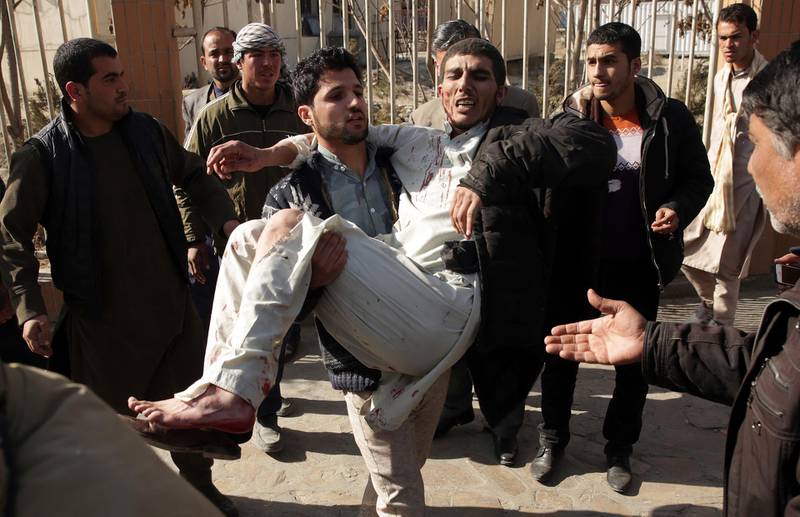 A wounded man is assisted at the site of a deadly suicide attack in the center of Kabul. Massoud Hossaini / AP Photo