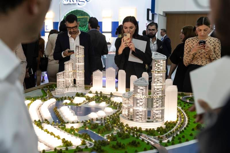 Visitors look at scale models of projects at the stand of Dubai developer Sobha Realty at Cityscape 2022.   
Antonie Robertson / The National
