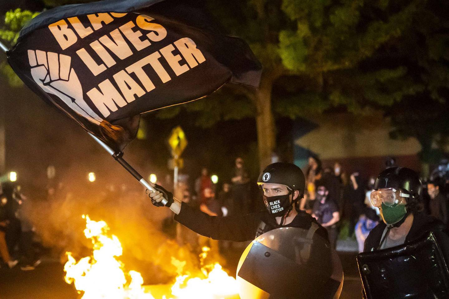 PORTLAND OR - SEPTEMBER 6: Protesters gather in front of a fire near the North police precinct during a protest against racial injustice and police brutality on September 6, 2020 in Portland, Oregon. Sunday marked the 101st consecutive night of protests in Portland.   Nathan Howard/Getty Images/AFP
== FOR NEWSPAPERS, INTERNET, TELCOS & TELEVISION USE ONLY ==

