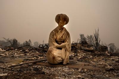 A Japanese style statue is seen in a neighbourhood destroyed by fire. AP Photo