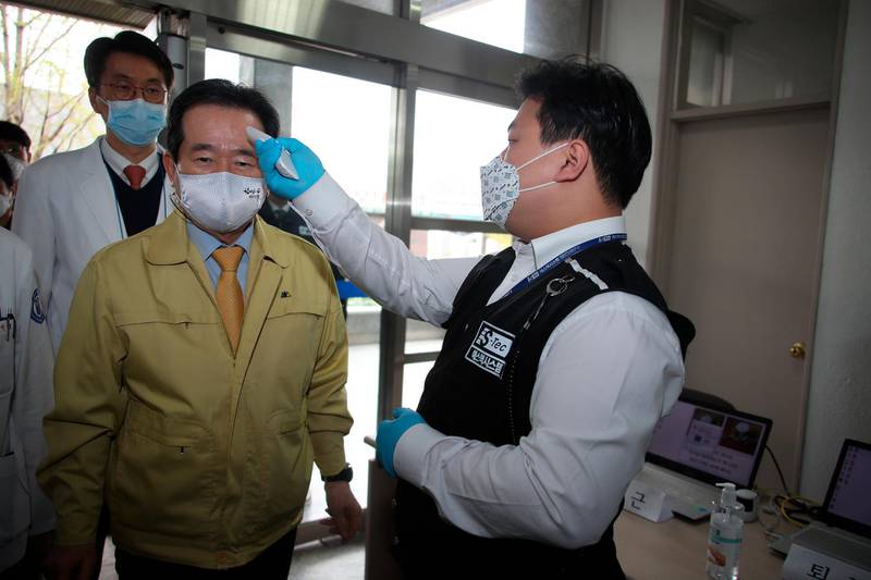 South Korean Prime Minister Chung Sye-kyun has his temperature checked upon arrival at Dongsan Medical Center in Daegu, South Korea. Yonhap via AP