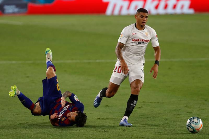 Lionel Messi falls next to Sevilla's Diego Carlos. AP