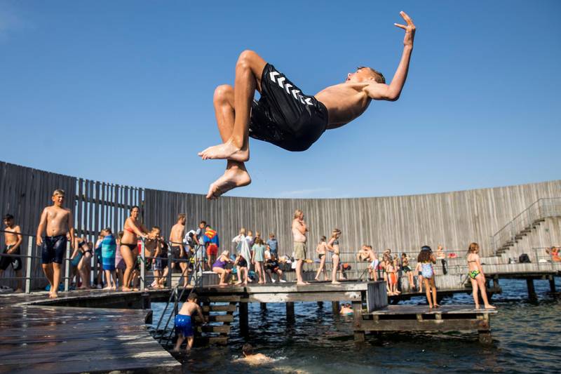Boys jump in the water at the Snail on Amager in Copenhagen, Denmark.  EPA