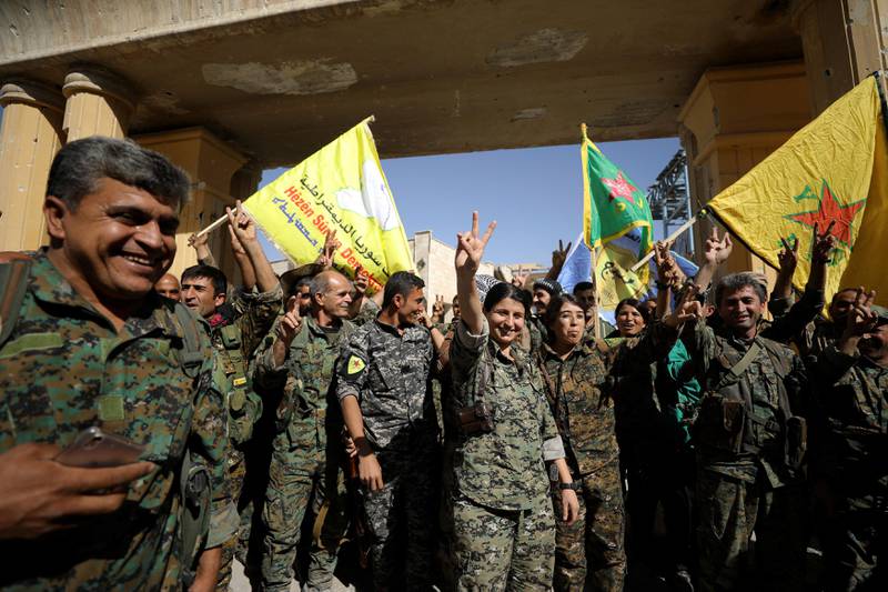 Fighters of Syrian Democratic Forces gesture the 'V' sign for victory in Raqqa. Rodi Said / Reuters