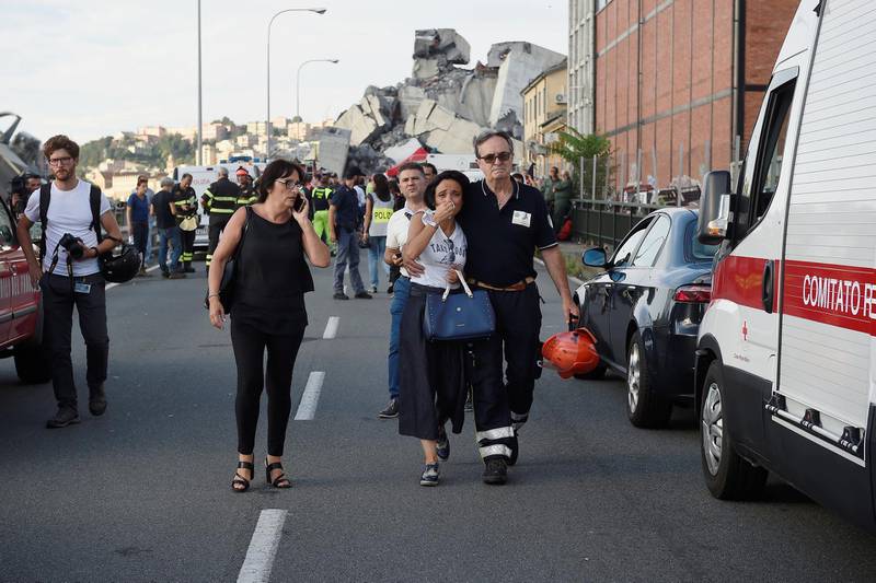 A woman cries while being embraced by a fire fighter as she leaves the site of the collapsed Morandi Bridge. Reuters