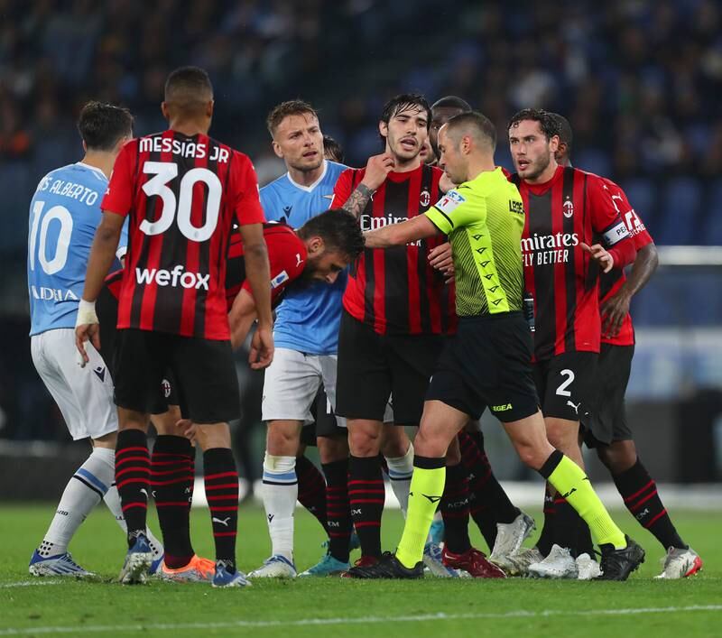 Davide Calabria and Sandro Tonali of AC Milan and Ciro Immobile of Lazio confront referee Marco Guida. Getty Images