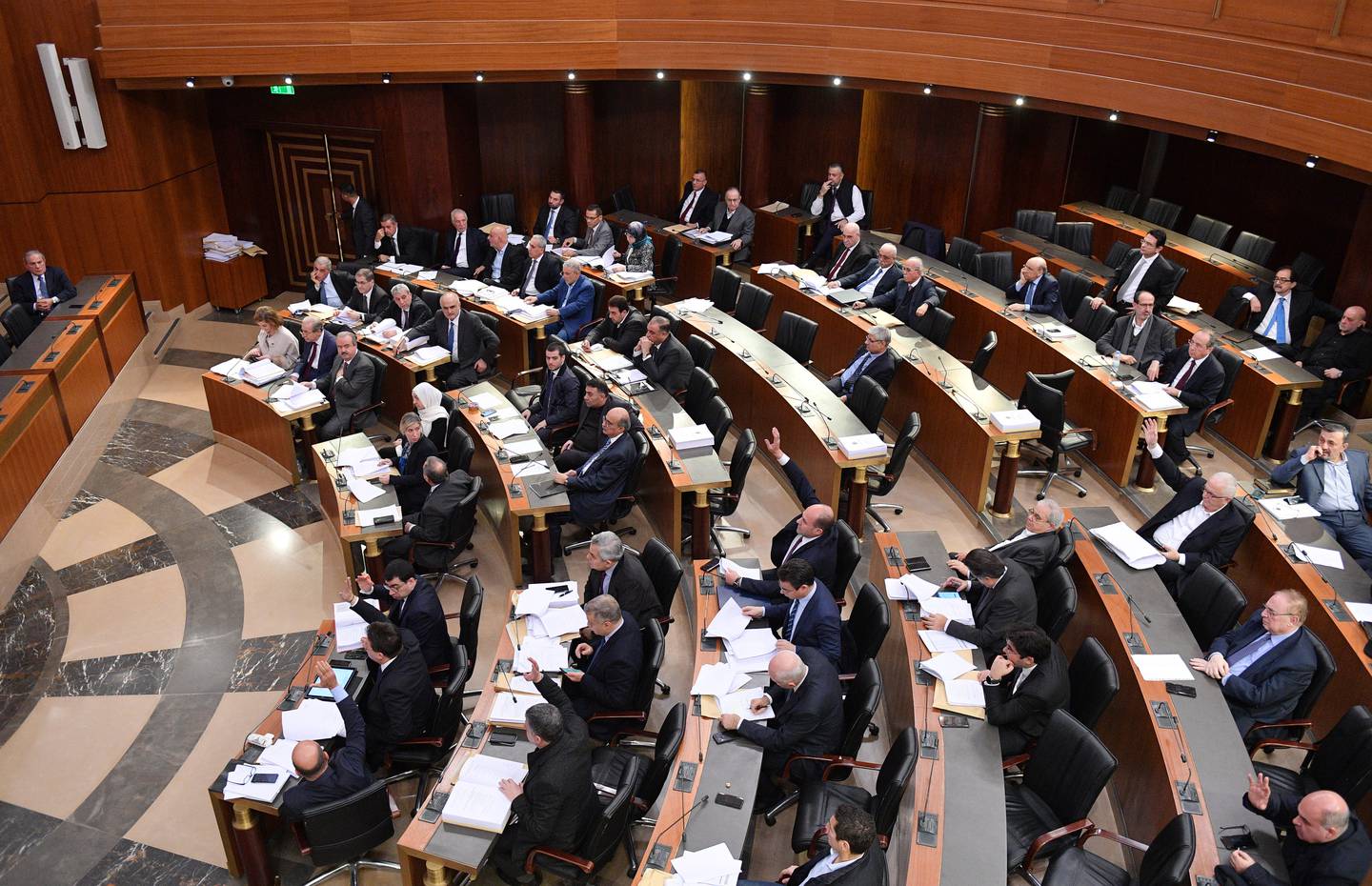 In this photo released by the Lebanese Parliament media office, Lebanese lawmakers vote for the 2020 budget at the parliament, in Beirut, Lebanon, Monday, Jan. 27, 2020. Under heavy security, Lebanese lawmakers on Monday endorsed a state budge for 2020 at a controversial session held amid a crippling financial crisis gripping the country. Outside the parliament building, protesters threw stones and sticks at security, who beat them back and detained several of the demonstrators. (AP Photo/ Hassan Ibrahim, Lebanese Parliament media office)