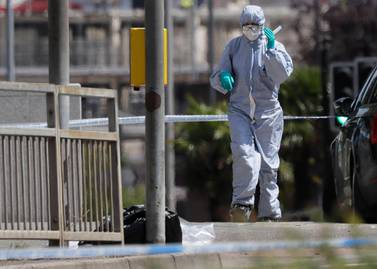 A police forensic officer works on a road near the scene of a fatal multiple stabbing attack in Reading, England. (AP Photo/Kirsty Wigglesworth)