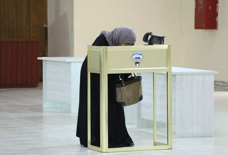A Kuwaiti woman casts her vote during parliamentary elections in Kuwait City. Kuwait is holding its most inclusive elections in a decade, with some opposition groups ending a boycott after the country's royal rulers pledged not to interfere with Parliament. AFP