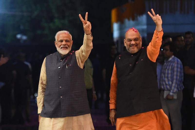 TOPSHOT - Indian Prime Minister Narendra Modi (L) and president of the ruling Bharatiya Janata Party (BJP) Amit Shah gesture as they celebrate the victory in India's general elections, in New Delhi on May 23, 2019.  Hindu nationalist Prime Minister Narendra Modi claimed victory on May 23 in India's general election and vowed an "inclusive" future, with his party headed for a landslide win to crush the Gandhi dynasty's comeback hopes. / AFP / Money SHARMA                        
