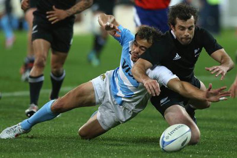 All Blacks' Conrad Smith struggles to reach the ball against Juan Martin Hernandez of Argentina during their Rugby Championship encounter in Wellington