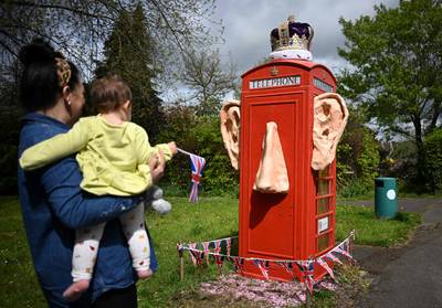 A telephone box in the village of Compton, Surrey, decorated with the ears, nose and crown of King Charles. AFP
