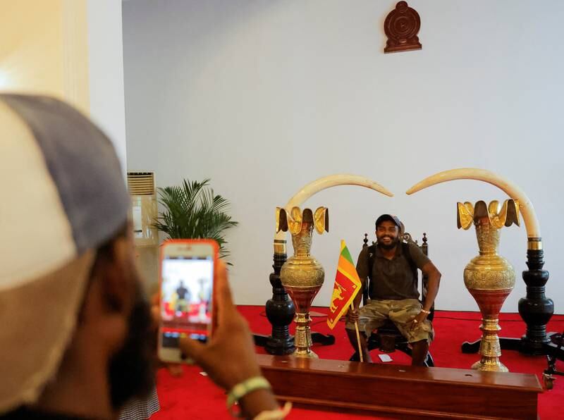 A demonstrator poses for photographs where President Gotabaya Rajapaksa used to hold events. Reuters