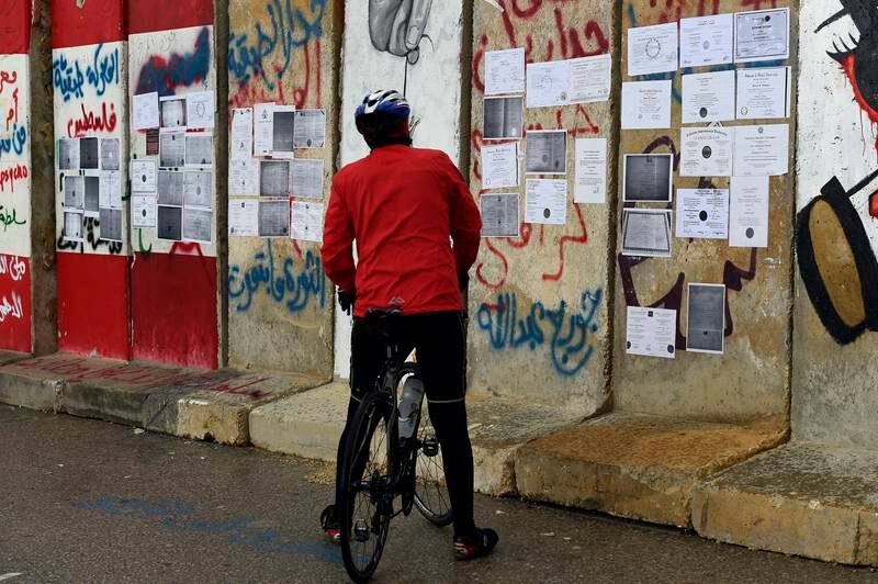 A man looks at university degrees placed by  unemployed graduates on a concrete wall set up by Lebanese police to block a road leading to the government palace in downtown Beirut. EPA
