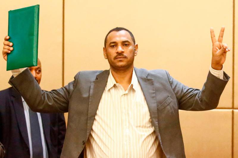 Protest leader Ahmed Rabie flashes the V sign for victory after signing the constitutional declaration with Sudan's deputy head of the Transitional Military Council, at a ceremony attended by African Union and Ethiopian mediators in the capital Khartoum on August 4, 2019. Sudan's army rulers and protest leaders today inked a hard-won constitutional declaration, paving the way for a promised transition to civilian rule. The agreement, signed during a ceremony witnessed by AFP,  builds on a landmark power-sharing deal signed on July 17 and provides for a joint civilian-military ruling body to oversee the formation of a transitional civilian government and parliament to govern for a three-year transition period. 
 / AFP / ASHRAF SHAZLY
