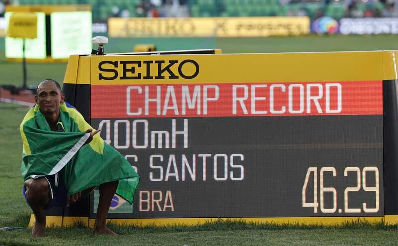 Alison Dos Santos poses next to the time board displaying his championship record at the World Athletics Championships. EPA