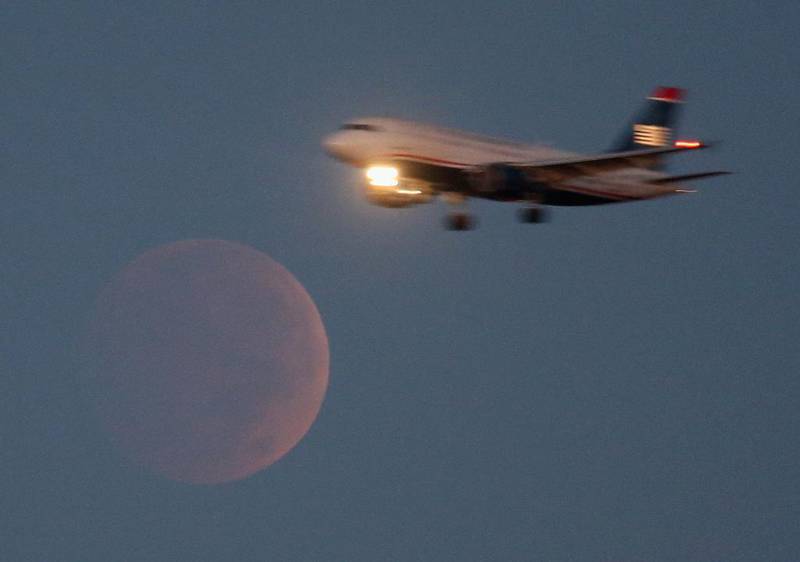 A commercial airliner on approach to Reagan National Airport flies past the full moon during the total lunar eclipse in Washington, DC. Mark Wilson, Getty Images/AFP