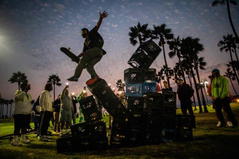 A man falls down of a pyramid of milk crates while he participates of the Milk Crate Challenge in Venice, California.  AFP