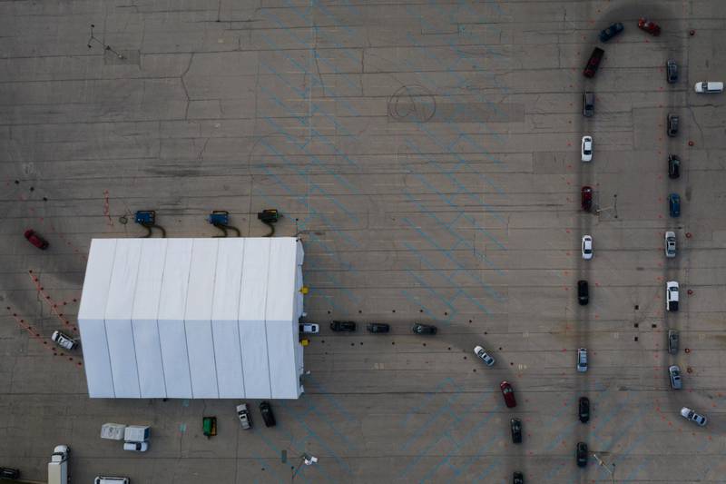 People in vehicles wait in line to enter a drive-thru Covid-19 testing site in a parking lot of Miller Park in Milwaukee, Wisconsin, USA. Bloomberg