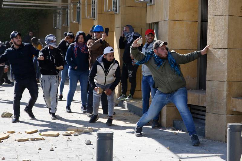Anti-government protesters throw stones at the riot police during a protest in downtown Beirut. AP Photo